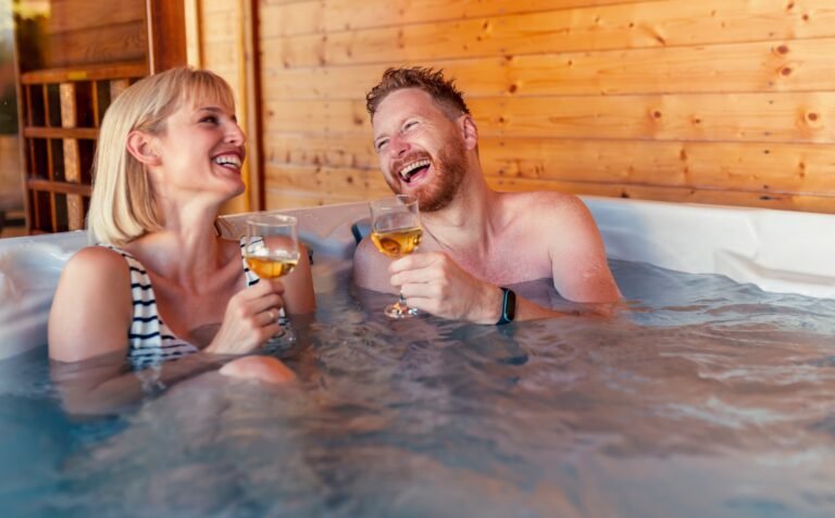 buying a hot tub-couple relaxing and drinking wine i a hot tub
