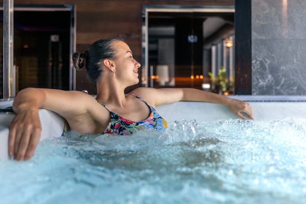 Woman relaxing in a hot tub at modern spa with bubbles. Quiet relax moment.